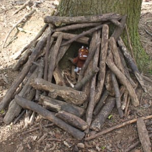 wooden house made of sticks in a wooded area for a toy Gruffalo