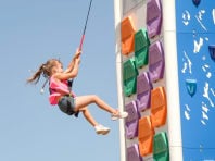 young girl on an outdoor climbing wall